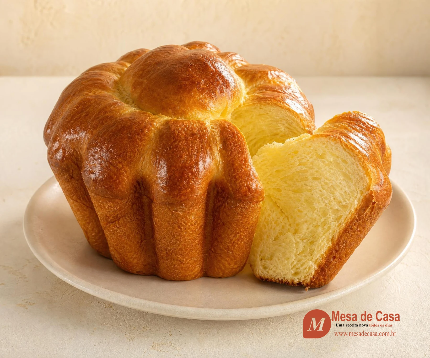 Brioche clássico dourado em forma canelada com uma fatia mostrando miolo amarelo e macio