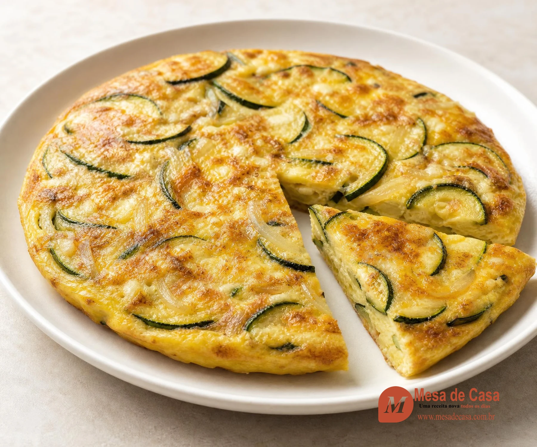 Frittata dourada com abobrinha e uma fatia cortada