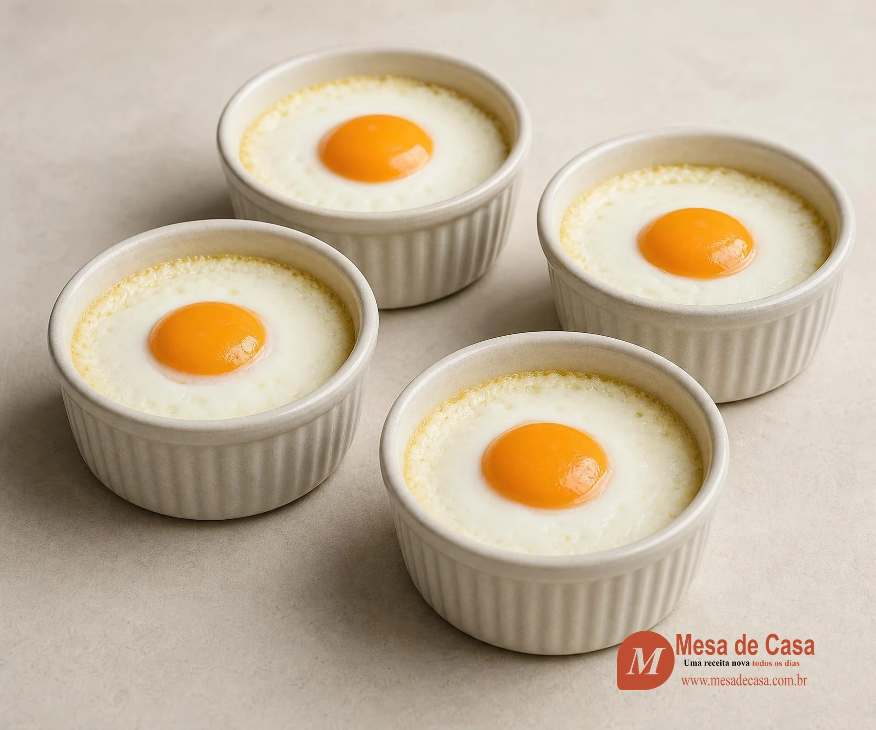 Quatro ramequins claros com ovos assados em creme, claras firmes e gemas brilhantes