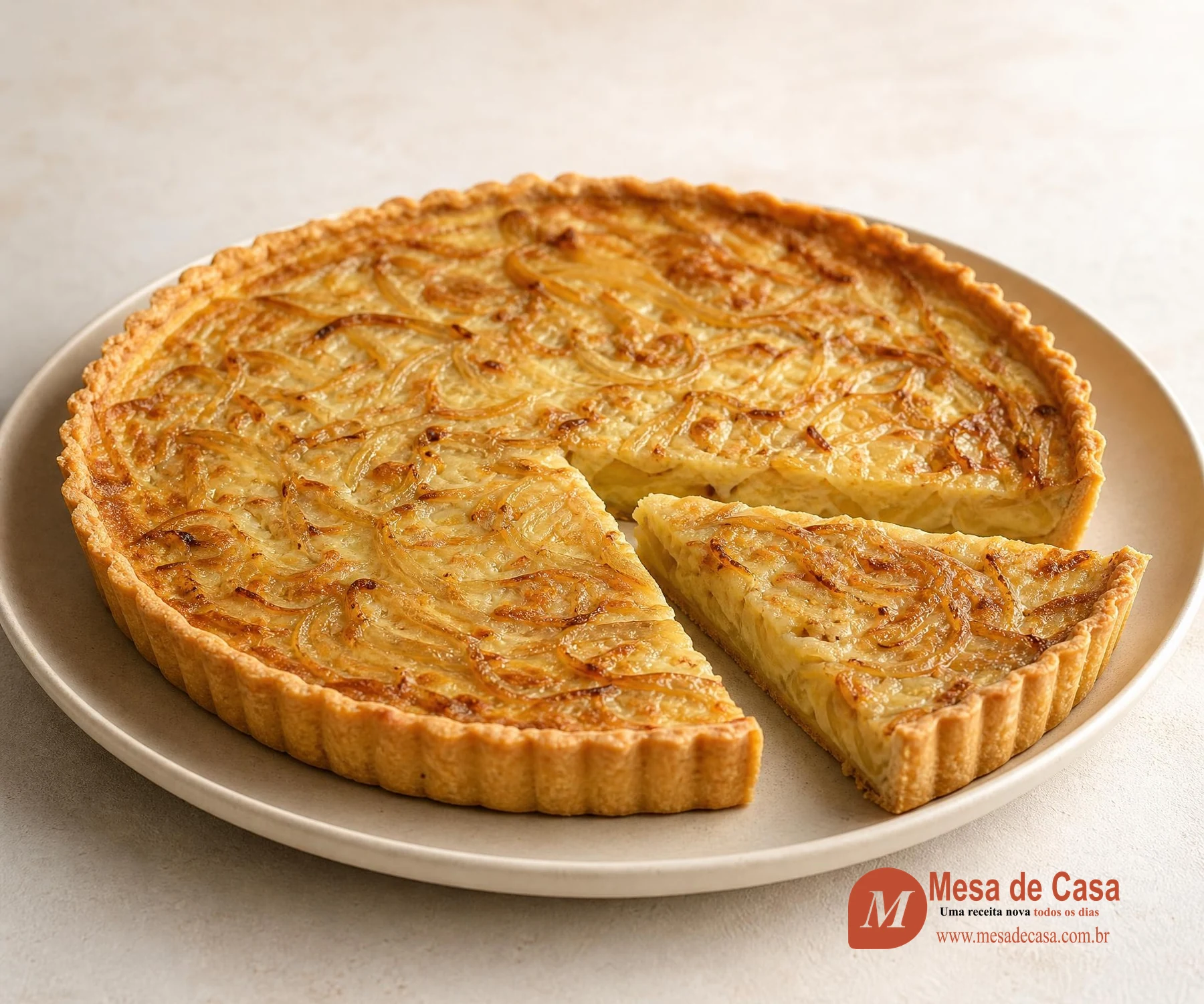Quiche dourada de cebola com uma fatia cortada mostrando recheio cremoso e massa fina