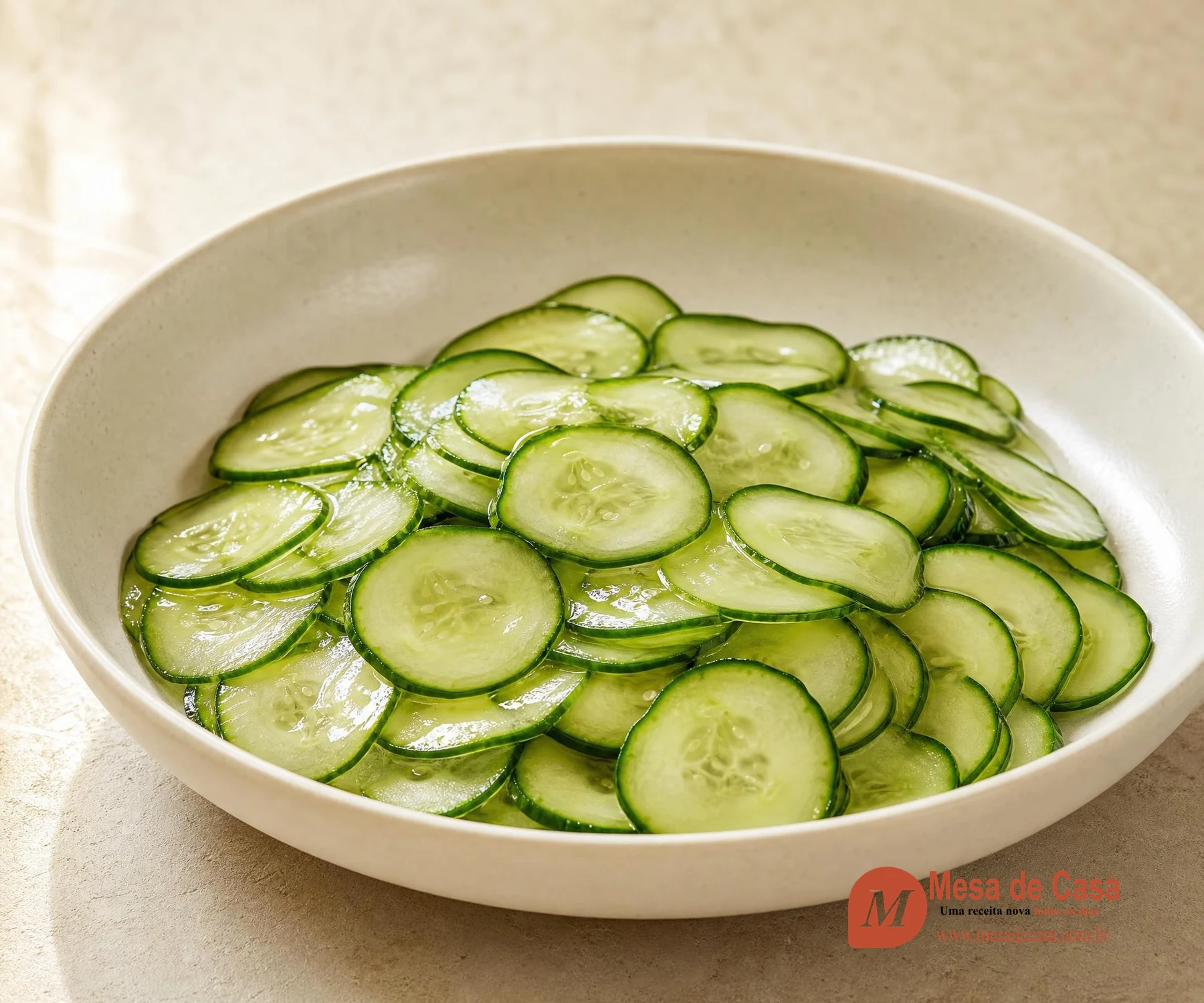 Rodelas muito finas de pepino brilhantes em molho agridoce dentro de tigela clara